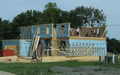 Wood-framed residential home under construction with workers at the upper level in Pittsfield Township, Michigan.