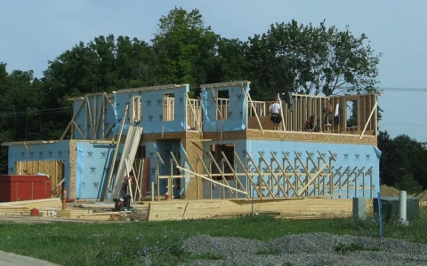 Wood-framed residential home under construction with workers at the upper level in Pittsfield Township, Michigan.