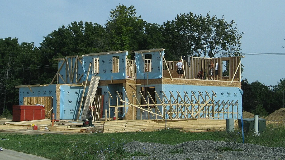 Wood-framed residential home under construction with workers at the upper level in Pittsfield Township, Michigan.