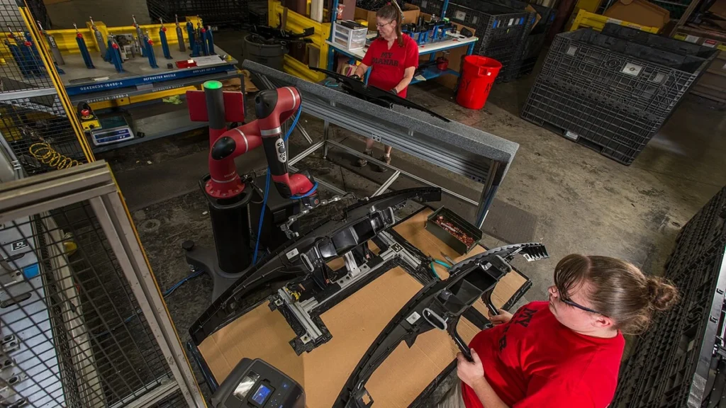 Workers and a collaborative robot on a factory floor at Tennplasco in Lafayette, Tennessee.