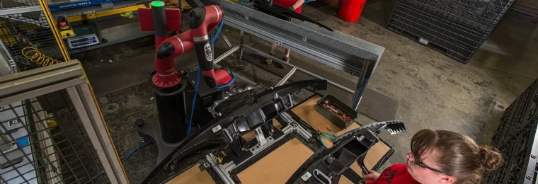 Workers and a collaborative robot on a factory floor at Tennplasco in Lafayette, Tennessee.