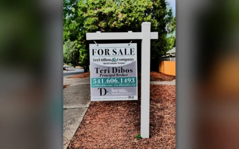 A real estate for-sale sign beside a residential street in Eugene, Oregon.