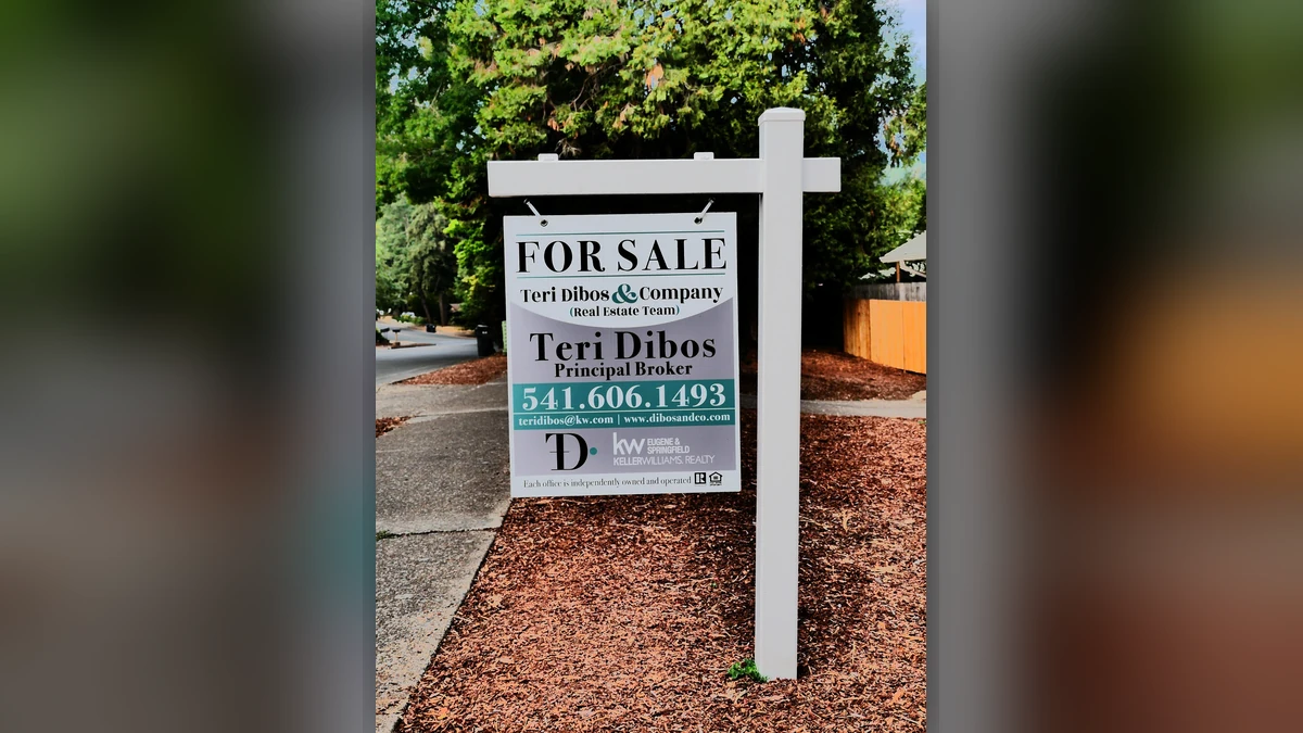 A real estate for-sale sign beside a residential street in Eugene, Oregon.