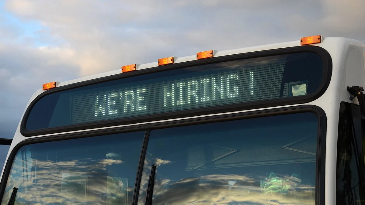 A TriMet bus in Portland, Oregon, displaying a We're Hiring sign on its electronic destination display.