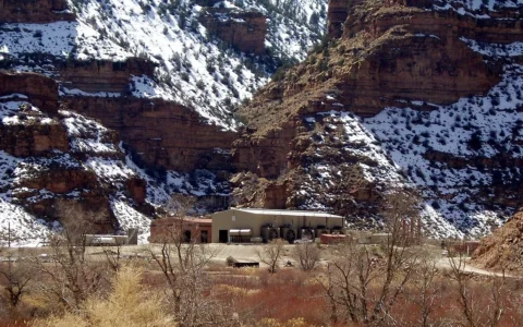 Natural gas compressor station in Nine Mile Canyon, Utah, with snow-covered canyon walls behind it.