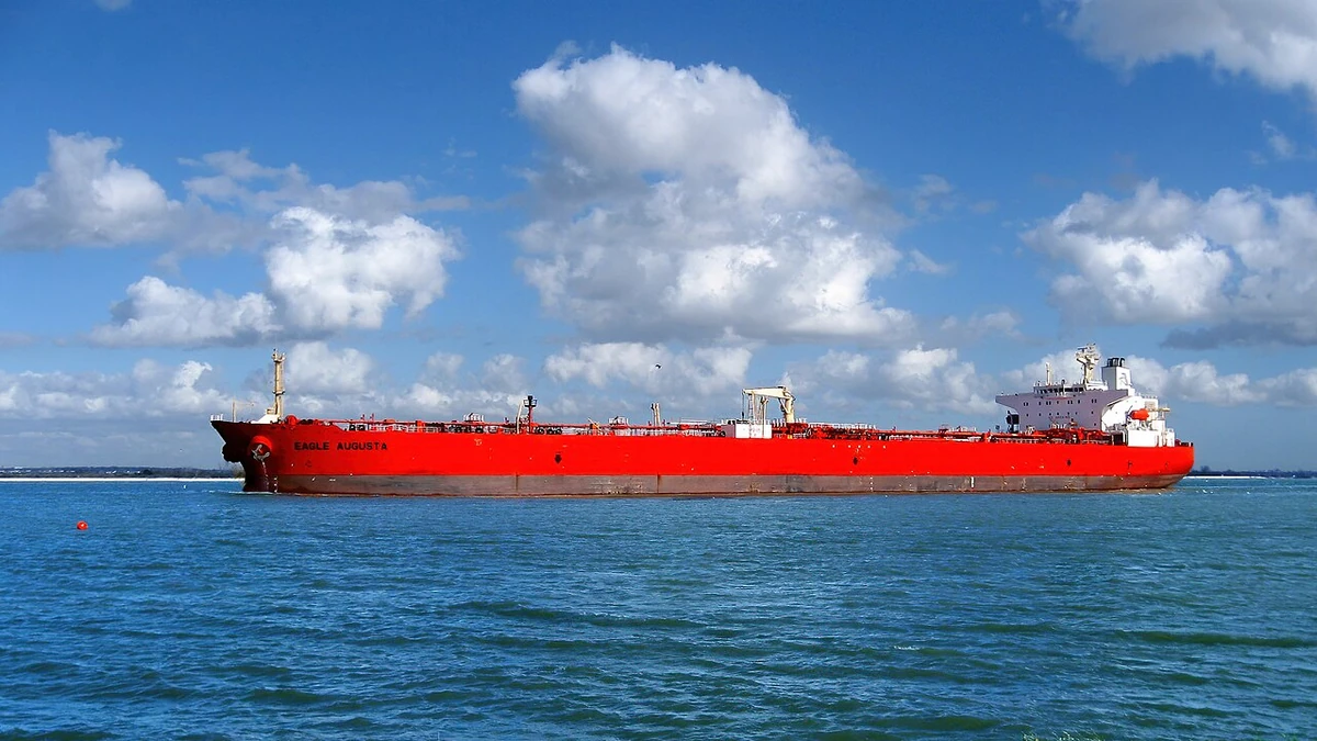 Red-hulled Eagle Augusta crude-oil tanker passing through waters near the Houston Ship Channel under a cloud-filled sky.