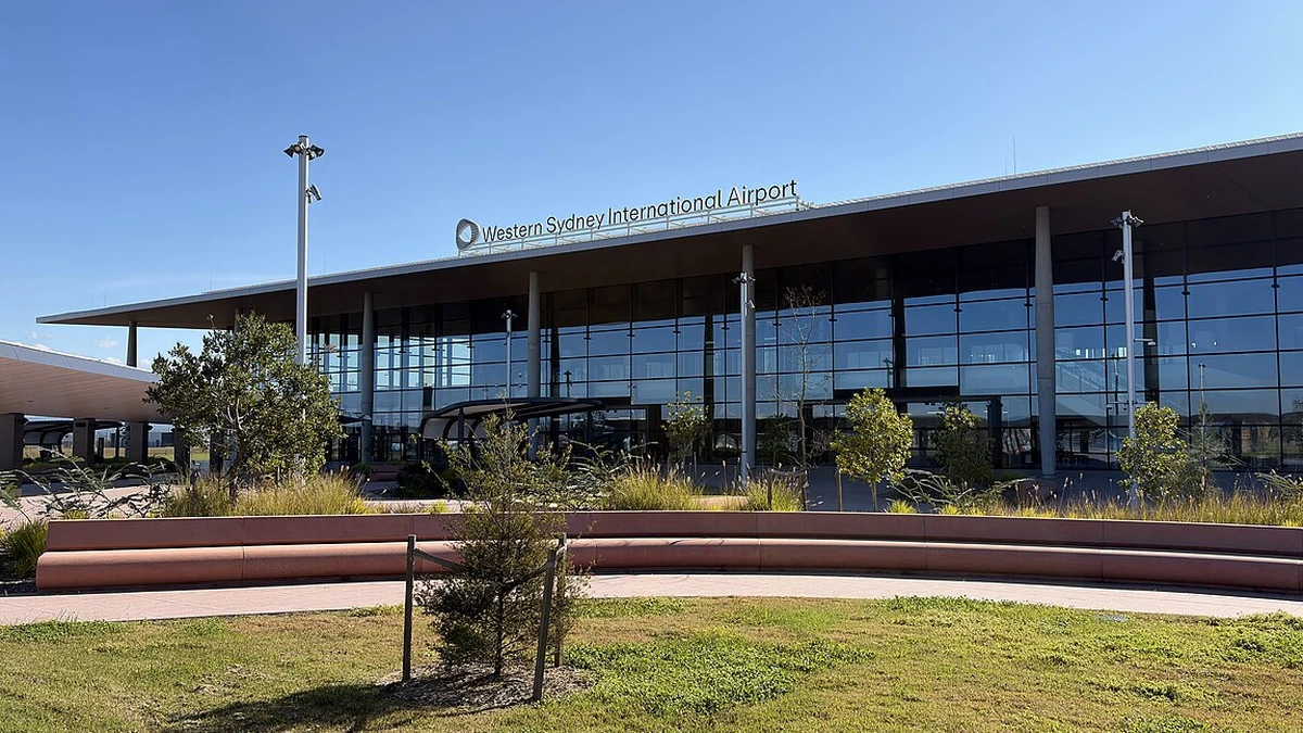 Glass-fronted Western Sydney International Airport passenger terminal with the airport name above the entrance.